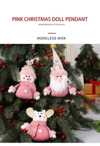 Detail of pink Christmas plush pendants including snowman and gnome on a green tree
