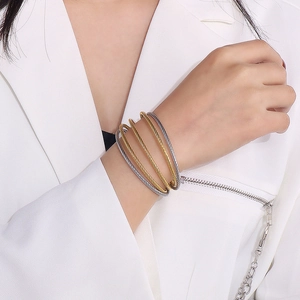 Detail of five-row twisted cable cuff bracelet in gold and silver steel on model