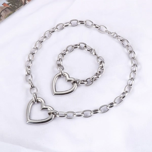 Detail view of chunky silver chain necklace and bracelet set with large heart pendants