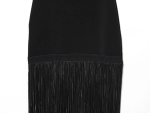 Détail d'une robe moulante noire avec de longues franges sur l'ourlet et texture premium