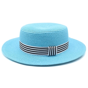 Close-up of sky blue straw boater hat featuring a black and white striped ribbon band