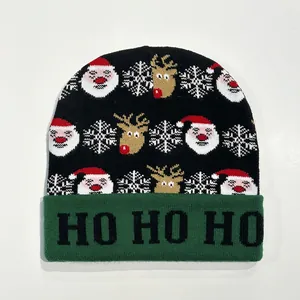 Detail of Christmas knit hat featuring Santa patterns and HO HO HO text on green cuff