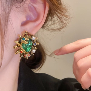 Close-up of vintage court style emerald pearl earrings worn on a female model ear