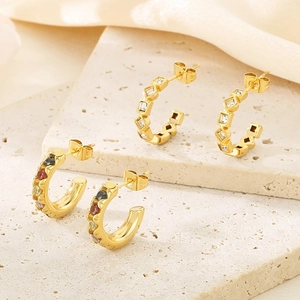 Détail de boucles d'oreilles en C plaquées or 18 carats avec zircons colorés sur pierre