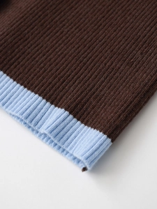 Detailed macro view of dark brown knit fabric with light blue contrast ribbing texture