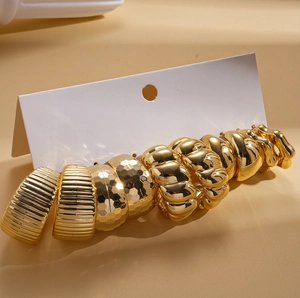 Detailed close-up of a 10-piece golden geometric C-shaped stud earring set on display card
