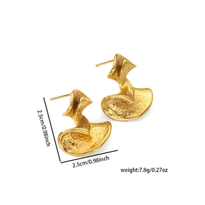 Detail shot of golden twisted metal earrings showing textured surface and 2.5cm size scale