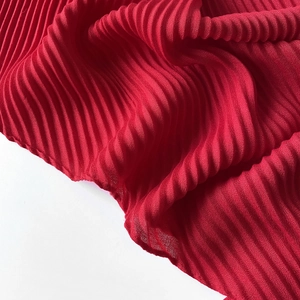 Detailed close-up showing the pleated texture and soft fabric of the red square silk scarf