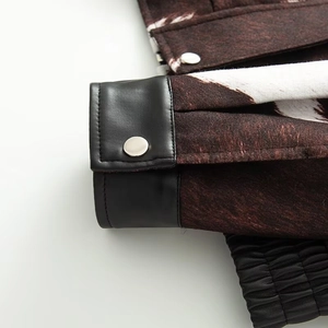 Detail of faux leather sleeve cuff with animal print fabric and silver metal button