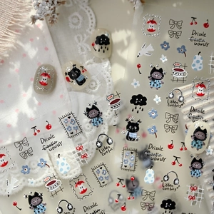 Cute cartoon cat nail stickers featuring red apples and blue dress motifs for nail art
