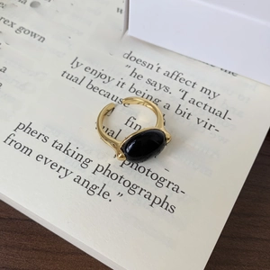 Detailed view of a gold plated 925 silver ring with oval black onyx on a book page