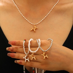 Dettaglio del set di gioielli con ciondolo a cane palloncino e bracciali di perle