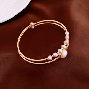Macro detail of gold plated multi-layer wrap bracelet with elegant freshwater pearls