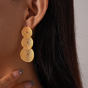 Close-up of model wearing gold mesh hollow geometric triple round earrings for women