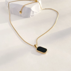 Macro detail of vintage geometric black onyx pendant with elegant gold chain