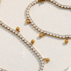 Detail of 18K gold plated chain featuring square zircons and dangling gold beads