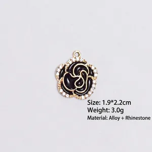 Detail view of a 1.9x2.2cm black enamel camellia pendant with white rhinestones