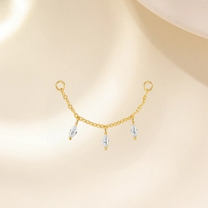 Détail d'un accessoire de boucle d'oreille en chaîne dorée avec zircons marquise