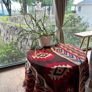 Detail of bohemian round blanket with geometric patterns and fringe edges on a table
