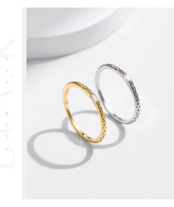 Macro detail of textured gold and silver rings with rectangular zircon center stones