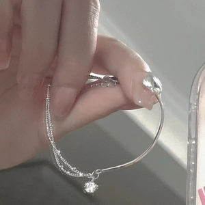 Silver double-layered star bracelet with fine snake chain worn on female wrist