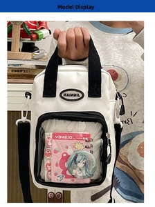 Detail view of the clear PVC display pocket with anime badges on the white canvas bag