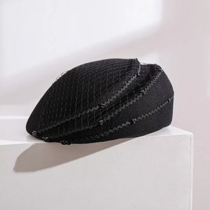 Elegant wool felt beret with mesh veil and bead decor on white geometric platform