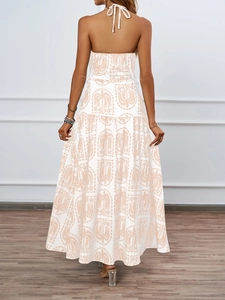 Detail of a backless halter floral dress showing tropical palm print and tiered maxi skirt