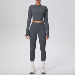 Détail d'un ensemble de yoga gris foncé avec trous pour les pouces et veste zippée