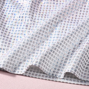 Detailed macro view of shimmering sequin plaid fabric with durable overlock stitch edges