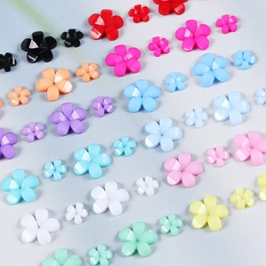 Macro shot of colorful resin flower beads in two sizes for DIY nail art and handmade crafts