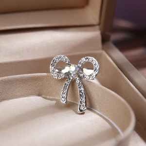 Elegant silver butterfly brooch with sparkling rhinestones in a luxury beige jewelry box