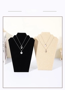 Detail of black velvet and beige linen necklace display stands with assorted jewelry