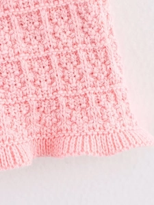 Detailed macro view of pink knit fabric texture with fine weave and ribbed edge design