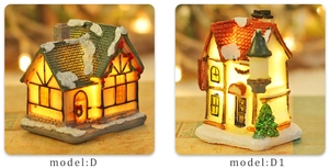 Close-up of lighted resin Christmas village house models D and D1 with warm LED glow