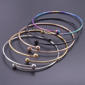 Detail view of five adjustable stainless steel bangles in multiple metallic finishes
