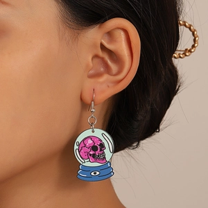 Detail of acrylic Halloween earring featuring a skull crystal ball design on a model