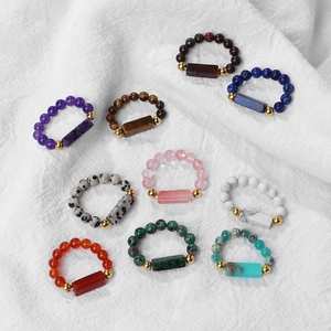 Detailed flat lay of boho 4mm natural gemstone beaded rings with gold spacer accents