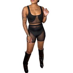 Detail of two-piece set featuring sheer mesh patchwork tank top and high-waisted shorts