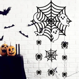 Halloween door hanger with glittery spider web, ghosts, and bats on white brick wall