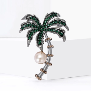 Green crystal coconut tree brooch with grey metal and white pearl pendant on white background
