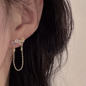 Macro shot of vintage style pink zirconia earrings featuring drop gems and gold chains