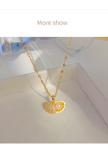 Detail of a gold-plated shell locket with white zircons and an inner pearl on a slim chain