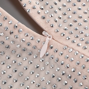 Détail de la robe en résille champagne avec strass argentés et fermeture éclair invisible