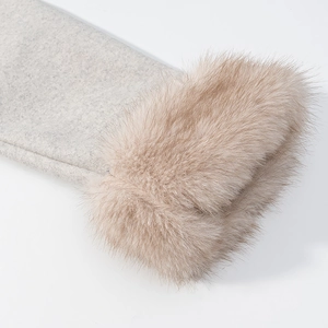 Dettaglio del polsino di cappotto di lana grigia con bordo in pelliccia marrone chiaro
