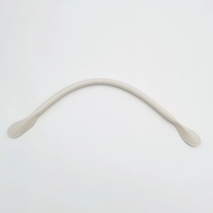 Detail of cream leather handbag strap featuring pre-punched sewing holes and padded core