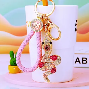 Detail of snake keychain with sparkling rhinestones and pink woven leather strap