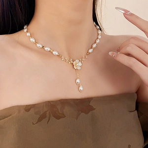 Détail du pendentif fleur plaqué or avec pompons de perles sur un collier vintage