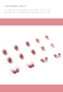 Detail of pink gradient press-on nails with white floral patterns and subtle glitter