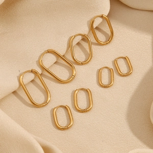 Detailed top view of various sized 18K gold-plated U-shaped earrings on satin fabric